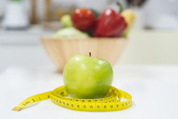 Diet breakfast concept. green apple and measure tape.
