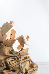 Miniature house model in the brown color Backpack on white background, Property investment concept, copy space, isolated