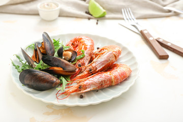 Plate with tasty shrimps and mussels on table