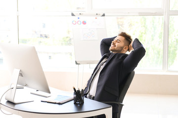 Handsome businessman having break during work in office