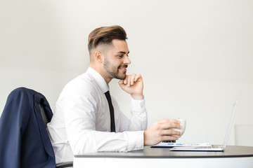 Handsome businessman having break during work in office
