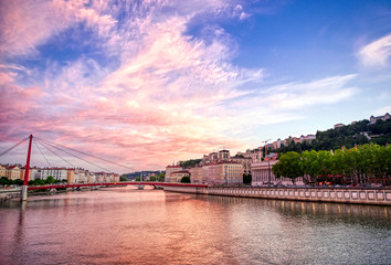 Obraz premium A view of Lyon, France along the Saône river at sunset.
