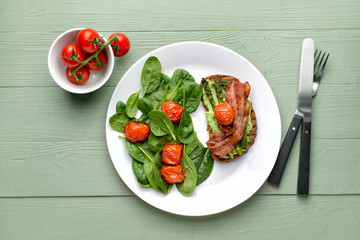 Plate with tasty toast and salad on wooden table