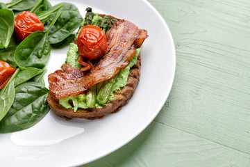 Plate with tasty toast and salad on wooden table