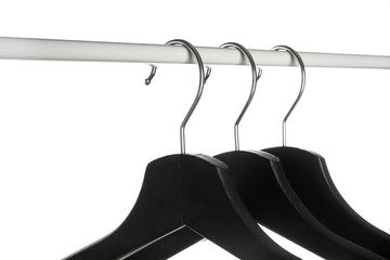 Rack with clothes hangers on white background, closeup