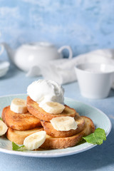 Plate with tasty French toasts, banana and ice cream on table