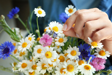 Young woman with bouquet of wild flowers, closeup