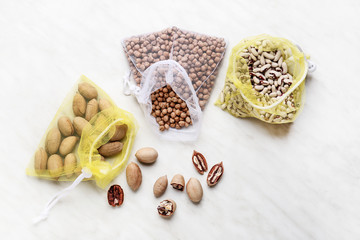 Eco bags with raw products on light background