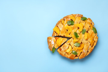 Tasty peach pie on color background