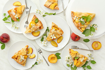 Pieces of tasty peach pie on light table
