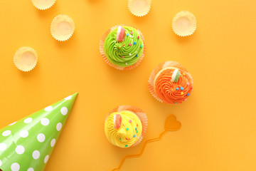 Sweet tasty Birthday cupcakes on color background