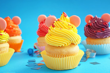 Sweet tasty Birthday cupcakes on color background