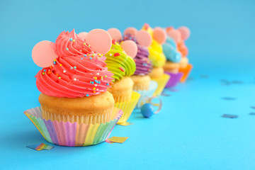 Sweet tasty Birthday cupcakes on color background