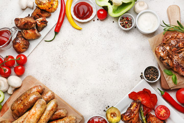 Frame made of tasty grilled meat with sausages and vegetables on light background