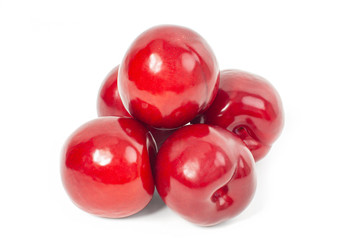 Fresh red plums on white background.