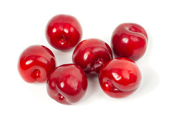 Fresh red plums on white background.