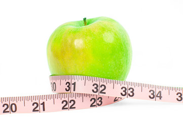 Dieting. Fresh green apple and measuring tape on white background.