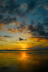 sunset  in bali with reflection of the sun on the beach