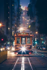 Deurstickers Zwart Klassieke weergave van historische traditionele kabelbanen die & 39 s nachts op de beroemde California Street rijden met stadslichten, San Francisco, Californië, VS