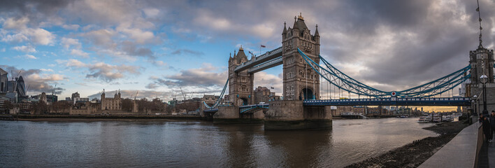 LONDON, ENGLAND, DECEMBER 10th, 2018: Tower Bridge in London, the UK. Sunrise with beautiful clouds. Panoramic view with White Tower and bullet like building. English symbols