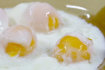 Close up shot of onsen tamago eggs in traditional Japanese or soft boiled eggs in Thai food in the white bowl on the wooden table.  cooking from hot spring  mineral water hot spring, Poached egg
