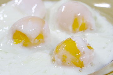 Close up shot of onsen tamago eggs in traditional Japanese or soft boiled eggs in Thai food in the white bowl on the wooden table.  cooking from hot spring  mineral water hot spring, Poached egg