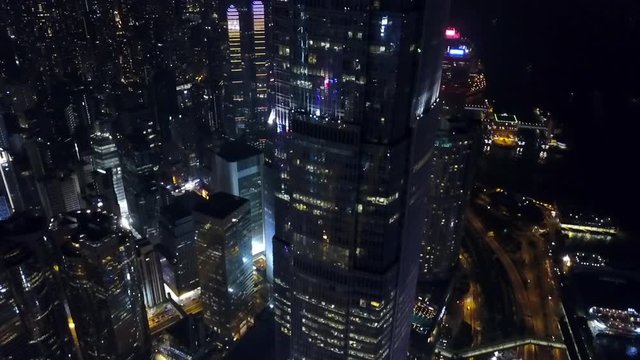 Aerial: Panning Down Skyscraper in Hong Kong City at Night