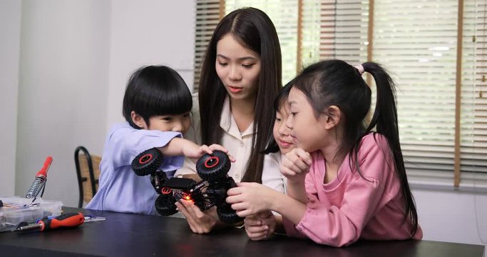 Teacher and student work on a programable robot at school science class project. Technology and Education concept.