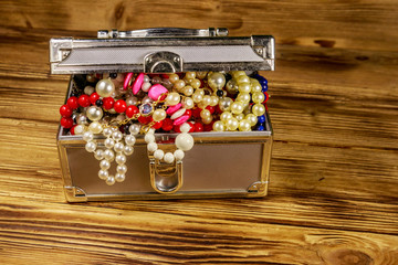 Jewelry box full of jewelry and accessories on wooden background