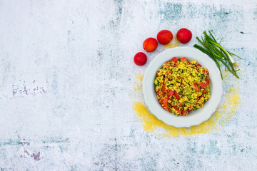 Tabbouleh - Levantine vegetarian salad made of chopped parsley, tomatoes, onion, bulgur or couscous and served with olive oil, lemon juice, salt and pepper. Space for text. Top above view