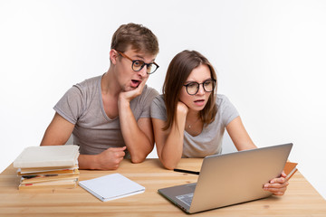 Nerds, study, people concept - a couple of people look at the laptop and look like surprised