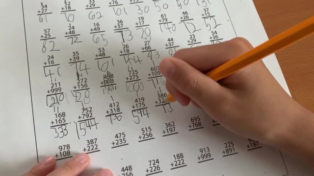 Child solving math problems with a number 2 pencil.