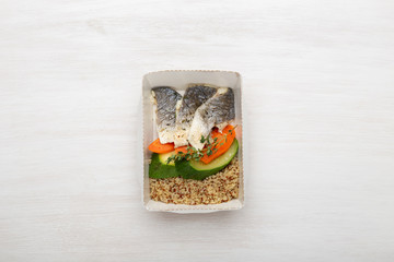 Top view slices of zucchini fish and wheat porridge next to slices of leek and carrot and seasonings. Healthy eating concept, copy space