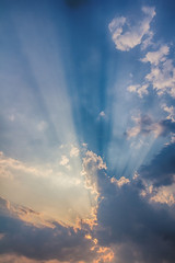 Fototapeta na wymiar Besutiful ray of sunlight breaking through clouds at sunset.