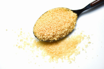 brown sugar in a spoon on white background