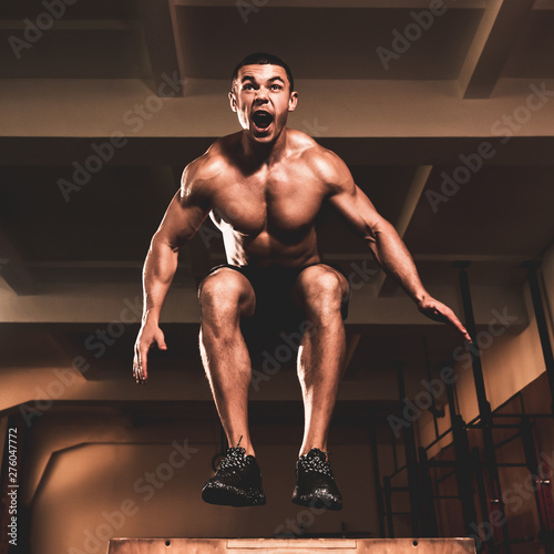 "Young muscular healthy bodybuilder doing box jump in gym" Stock photo