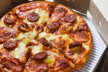 pizza in box close up / delicious tasty fast food italian traditional pizza cheese