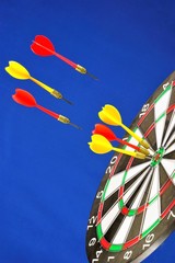 Target for sports Darts fly to the center, on a blue background. A game in which players rivals...
