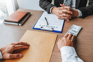 Corruption and Bribery,Businessman giving dollar bills corruption bribery to business manager to deal contract