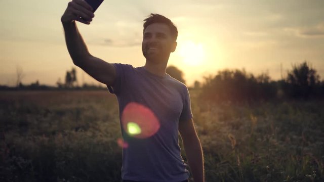 Taking Selfie Photo At Sunset.Man Taking Selfie At Sunrise.Happy Man Taking Selfie By Mobile Phone.Male Self Photo With Mobile Phone.Male Self Phtotographing. Photographing At Sunset.Male Makes Photos