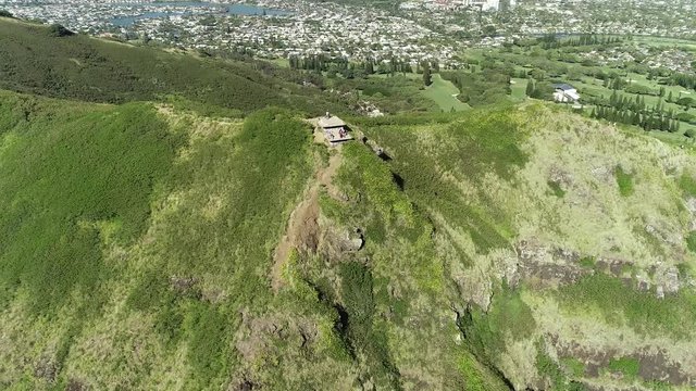 Aerial view of Lanikai beach, Honolulu, Hawaii, low angle view with drone camera moving forward, people taking pictures on pill box world war II monument, color graded