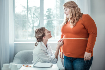 Kind plump girl talking to her doctor