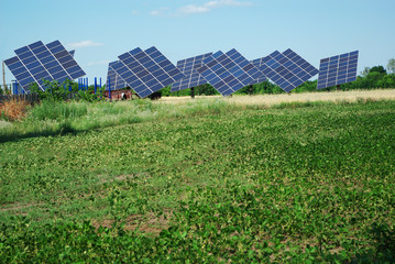 Solar panels on a green field against a blue sky