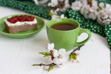 A tasty break: a cup of tea with a rye bread sandwich.