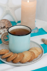 A study break: a mug of tea with cookies on a side.