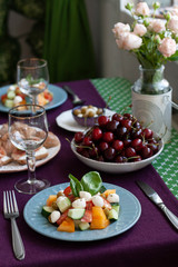 Naklejka na ściany i meble A gourmet lunch for two: a salad, fresh cherries and various appetizers.