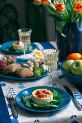 A gourmet dinner: grilled camembert, a glass of wine and various appetizers.