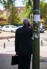 Persona mayor con traje hablando por tel&eacute;fono m&oacute;vil 