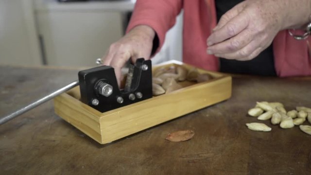Closeup of a woman cracking Galip nuts