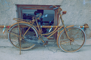 Naklejka na ściany i meble City Riga, Latvian Republic. Rusty bicycle standing on the edge of the street. Travel photo 2019. 25. Jun.
